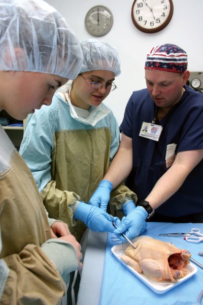 US Navy 040331-N-5821W-005 Hospital Corpsman 2nd Class Damon Denton shows eighth-grade students from Naval Air Station Sigonella's Stephen Decatur School how to perform a suture using a chicken