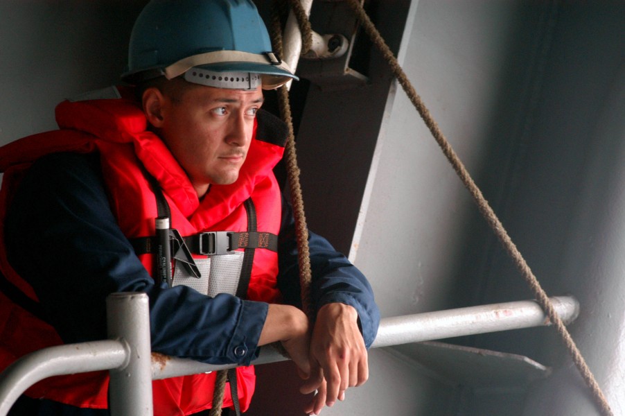 US Navy 040825-N-1671M-033 Boatswain^rsquo,s Mate 3rd Class Robert Natividad, of Pecos, Texas, assigned to deck department, waits for the signal for more slack from crew members aboard the starboard Rigid Hull Inflatable Boat (