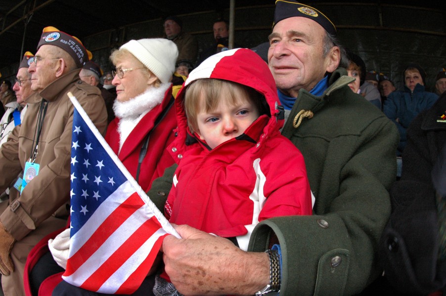 US Navy 041216-N-3236B-008 A young man keeps warm on his grandfather's lap during ceremonies held at the Mardassom Monument in Bastogne, Belgium