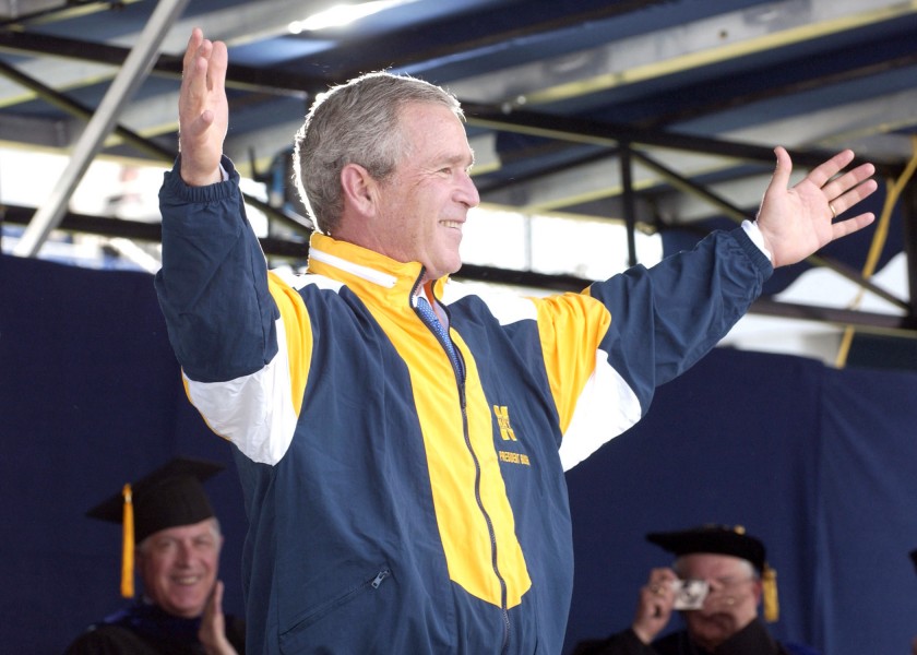 US Navy 050527-N-5390M-206 U.S. President George W. Bush tries on a Naval Academy windbreaker presented to him by a graduating Midshipman during the 2005 Naval Academy Graduation Ceremony