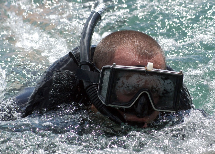 US Navy 050913-N-3019M-009 Fire Controlman 2nd Class Matthew Paga, assigned to the guided missile destroyer USS Chung-Hoon (DDG 93), simulates a swimmer attack scenario during an anti-terrorism-force protection exercise
