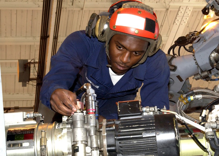 US Navy 060405-N-1126D-004 Airman Kennie Robinson performs routine maintenance on an SH-60 Seahawk helicopter hydraulic pump