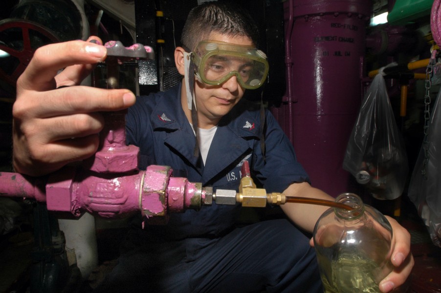 US Navy 060909-N-3946H-086 Aviation Boatswain's Mate Fuels 3rd Class Juan Sosa, from Cedartown, Calif., takes a sample of JP-5 jet fuel to check for impurities, in the number Two JP-5 pump room, aboard USS Kitty Hawk (CV 63)