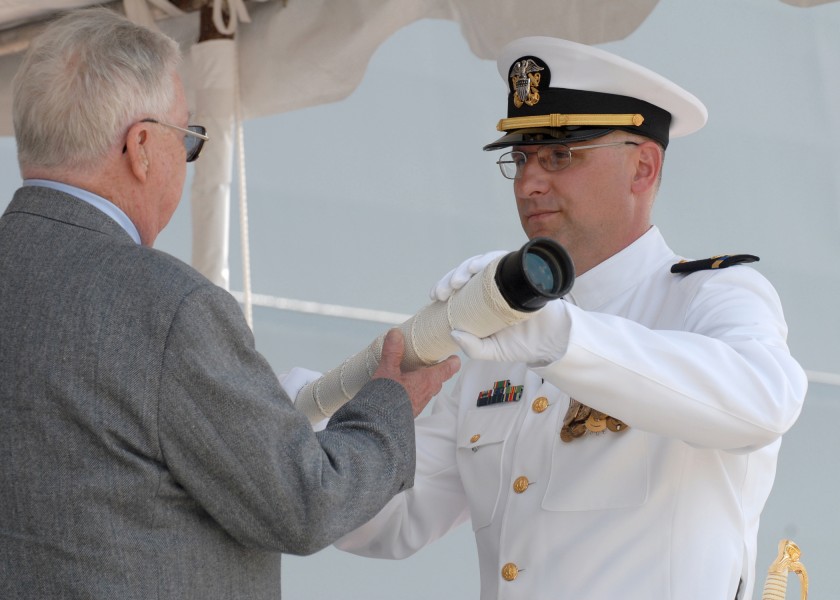 US Navy 070310-N-9909C-002 Retired Senior Chief Fire Control Technician Hank Wristen, passes the ship's long glass to Chief Warrant Officer Robert McLaughlin