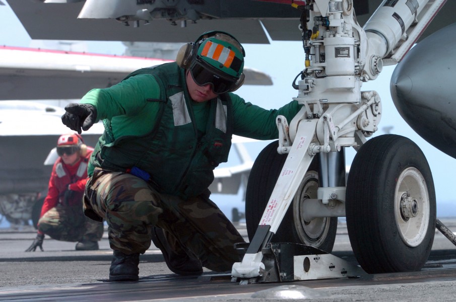 US Navy 070423-N-4420S-043 Aviation Boatswain^rsquo,s Mate Equipment 3rd Class Josh Stonestreet signals to send the catapult forward to prepare an F-A-18C Hornet for launch aboard nuclear-powered aircraft carrier USS Nimitz (CV