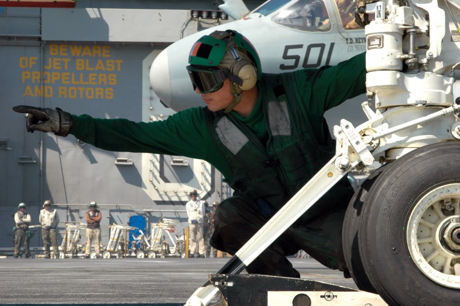 US Navy 070620-N-8119R-175 Aviation Boatswain^rsquo,s Mate (Equipment) 2nd Class Ricky Criswell signals that an F-A-18E Super Hornet, assigned to the Tophatters of Strike Fighter Attack Squadron (VFA) 14, is hooked up to the ca