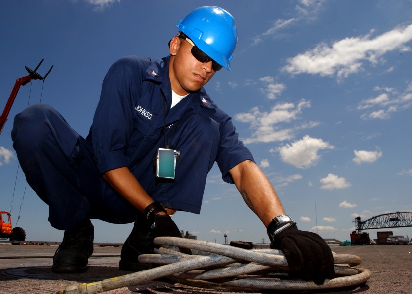 US Navy 070723-N-7241L-001 Aviation Boatswain's Mate (Handling) 3rd Class Terrence Johnson, of Saginaw, Mich., wraps up an air hose while preparing for rehabilitative work on the flight deck of USS Theodore Roosevelt (CVN 71)