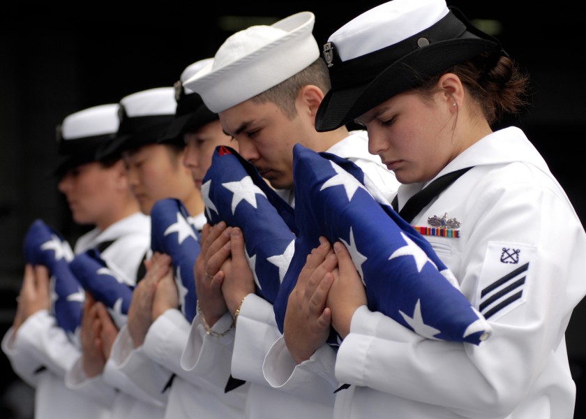 US Navy 070819-N-7981E-605 Flag bearers bow their heads in prayer during a burial at sea ceremony aboard Nimitz-class aircraft carrier USS Abraham Lincoln (CVN 72)