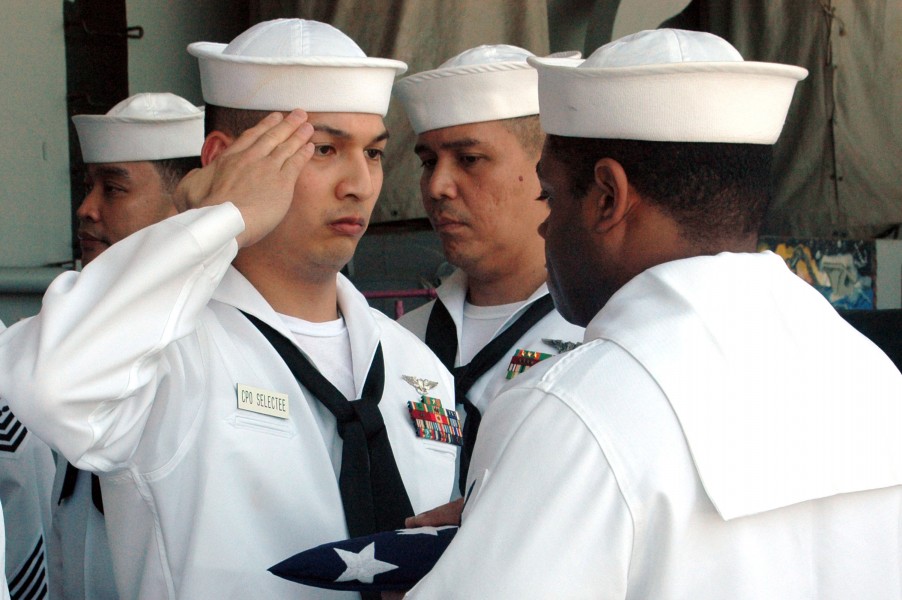 US Navy 070822-N-3136P-062 Aviation Ordnanceman 1st Class Elison Talabong, a chief petty officer selectee, renders a salute to the national ensign aboard USS Kitty Hawk (CV 63)