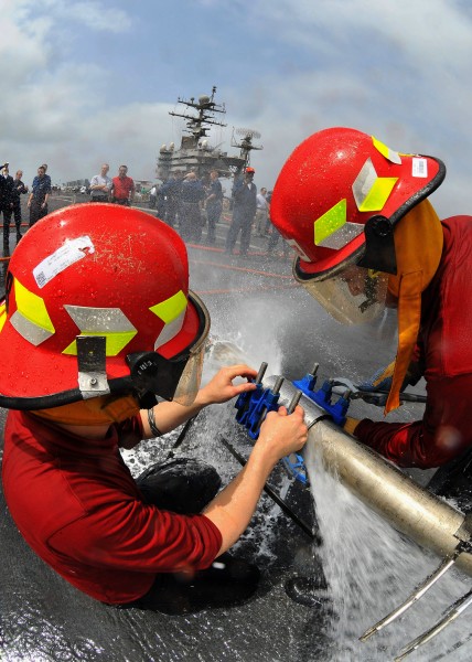 US Navy 080726-N-1745W-539 Aviation Ordnanceman 2nd Class Mitchell Lopez, from Gallup, N.M., and Aviation Ordnanceman 2nd Class Jason Davidson, from East Icelip, N.Y., patch a simulated pipe leak during a damage control Olympic