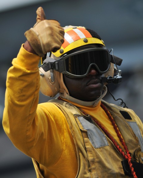 US Navy 080814-N-7981E-128 Aviation Boatswain's Mate (Handling) 1st Class Corey Cooper gives a thumbs up while directing aircraft on the flight deck of the Nimitz-class aircraft carrier USS Abraham Lincoln (CVN 72)
