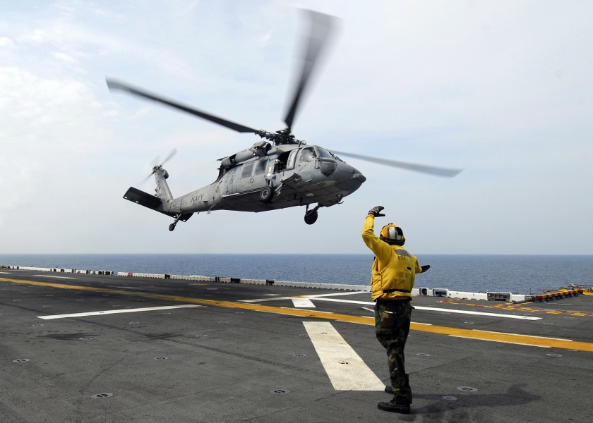 US Navy 080829-N-4236E-189 Aviation Boatswain's Mate Handling Airman Tyrone Williams signals to an MH-60S Sea Hawk from Helicopter Sea Combat Squadron (HSC) 26 aboard the multi-purpose amphibious assault ship USS Iwo Jima (LHD 