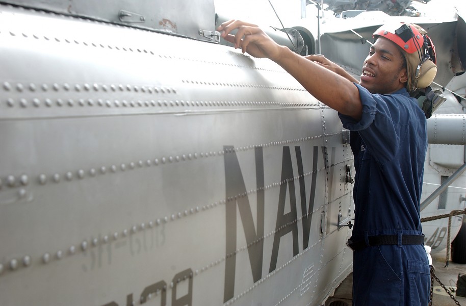 US Navy 080902-N-1522S-008 Aviation Ordnanceman Airman Jerome Mckenzie inspects a helicopter drive shaft