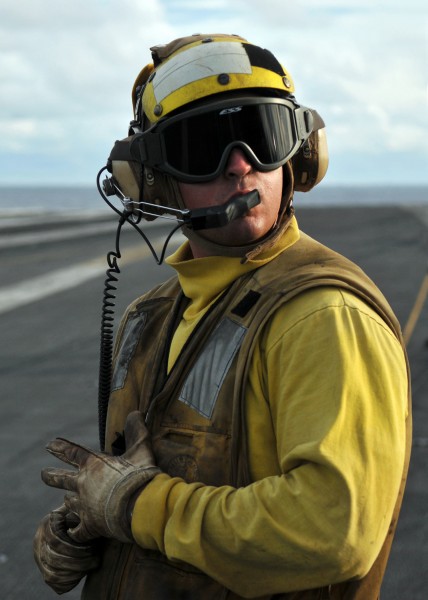 US Navy 080906-N-7981E-157 Aviation Boatswain's Mate (Handling) Airman Sean Bibby, from Dunellen, N.J., an aircraft director, communicates with flight deck control while waiting to launch an aircraft from the waist catapults on