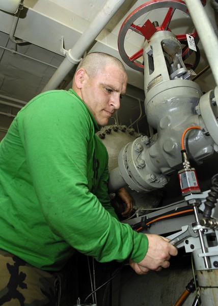 US Navy 081022-N-4954I-006 Aviation Boatswain's Mate (Equipment) 3rd Class Andy Boucher performs maintenance on an aircraft catapult hydraulic system
