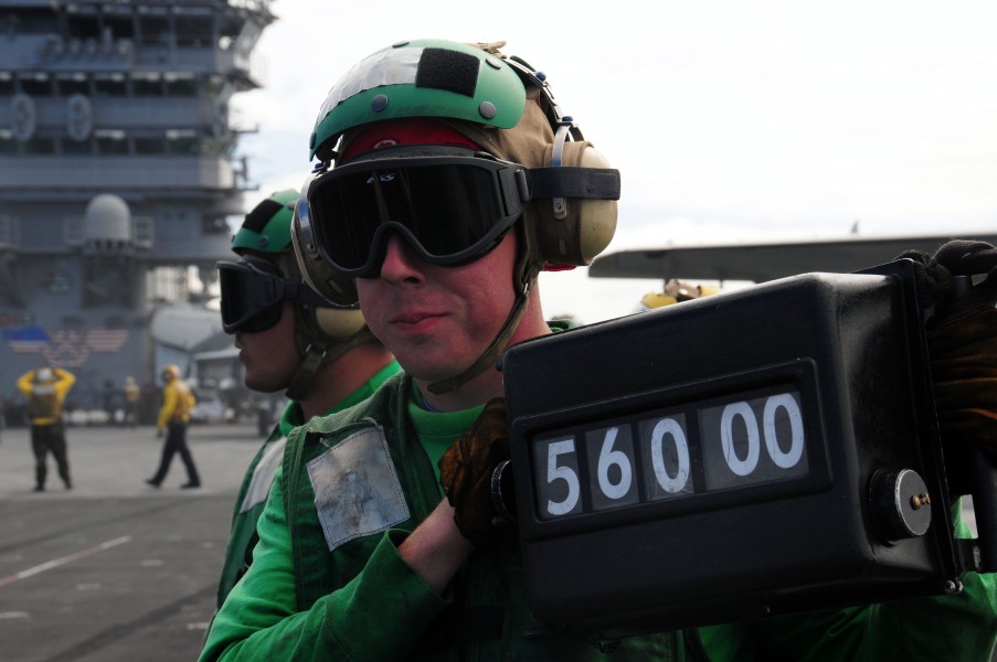 US Navy 090225-N-3946H-050 Aviation Boatswain's Mate (Equipment) 3rd Class Doug Bellew displays the weight of an F-A-18F Super Hornet