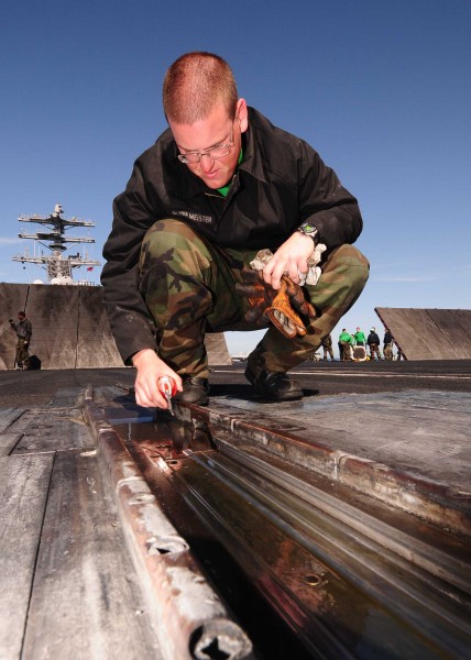 US Navy 090324-N-9760Z-012 Aviation Boatswain's Mate (Equipment) Airman Nicoles Schulmeister, lubricates the nose gear launch assembly of catapult number three
