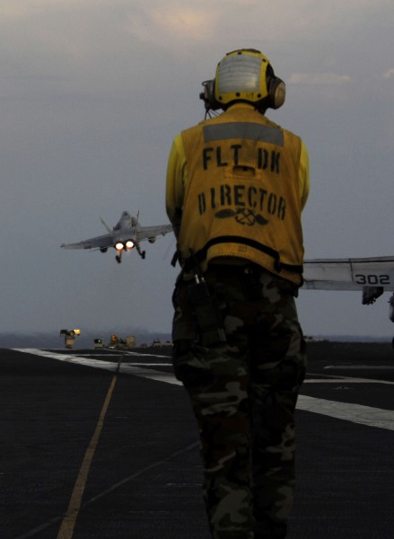 US Navy 090504-N-6538W-165 Aviation Boatswain's Mate (Handling) 1st Class Richard Smith, from Fort Worth, Texas, watches as an F-A-18C Hornet from the Death Rattlers of Marine Strike Fighter Squadron (VMFA) 323 launches from th