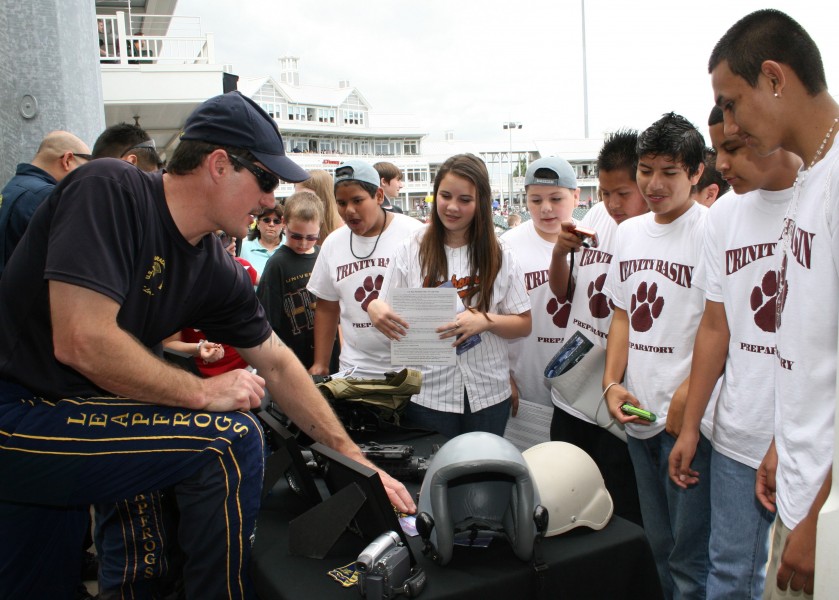 US Navy 090506-N-5366K-144 Chief Special Warfare Operator (SEAL) William Davis, assigned to the U.S. Navy Parachute Team the Leap Frogs, shows children military equipment at Dr. Pepper Ball Park after the Team parachuted into t