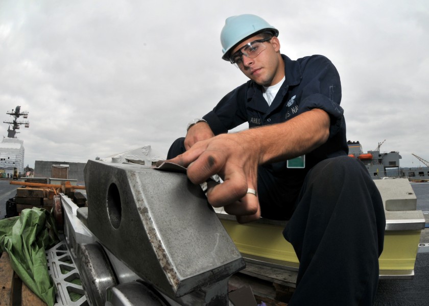 US Navy 090805-N-5386R-037 Aviation Boatswain's Mate (Equipment) Airman Ignacio Arbildi, from Las Vegas, sands a catapult boot aboard the aircraft carrier USS Abraham Lincoln (CVN 72)