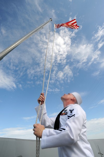 US Navy 090821-N-2147L-001 Information Systems Technician 2nd Class James Alcorn raises the Navy Jack for the first time aboard the amphibious transport dock ship Pre-Commisioning Unit (PCU) New York (LPD 21)