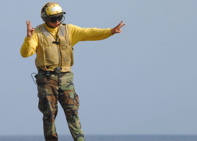 US Navy 091029-N-5538K-038 Aviation Boatswain's Mate (Handling) Airman Recruit Timothy M. Fulfer signals the pilot of a Marine Corps CH-53E Sea Stallion helicopter