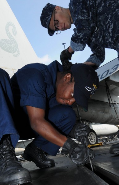 US Navy 091203-N-3038W-048 Aviation Boatswain's Mate (Equipment) Airman Latia Davis and Aviation Boatswain's Mate (Equipment) Airman Kevin Rooker perform maintenance on a catapult