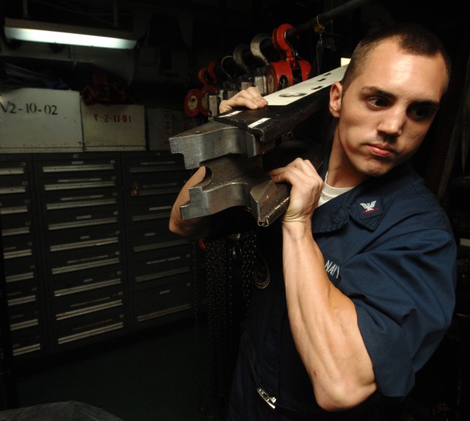 US Navy 100721-N-6582H-024 Aviation Boatswain's Mate (Equipment) 3rd Class Victor Guarnieri grabs a spreader from the maintenance tool room aboard USS Harry S. Truman (CVN 75)