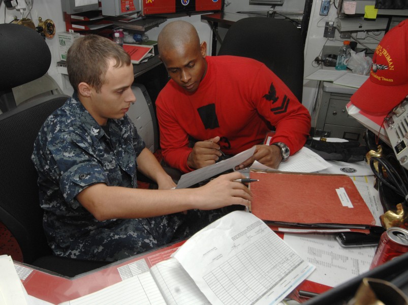 US Navy 100721-N-6582H-056 Aviation Ordnanceman 2nd Class Shawn Locklear and Aviation Ordnanceman 2nd Class Emmanuel Mitchell review records in the ordnance control office aboard USS Harry S. Truman (CVN 75)