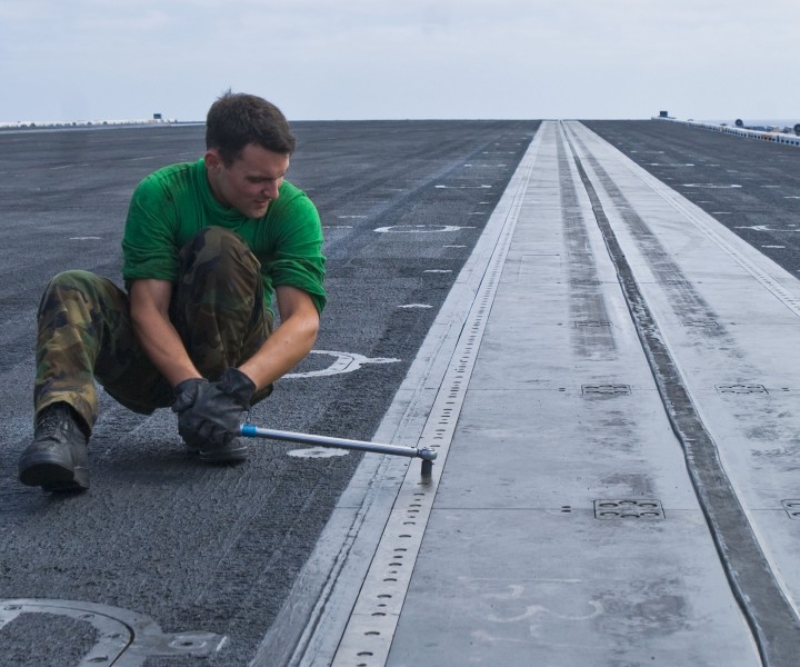 US Navy 100830-N-1276B-057 Aviation Boatswainâ^euro,^trade,s Mate (Equipment) Airman Robert M. Horvath torques the catapult deck plates after an in-deck shuttle inspection aboard USS Nimitz (CVN 68)
