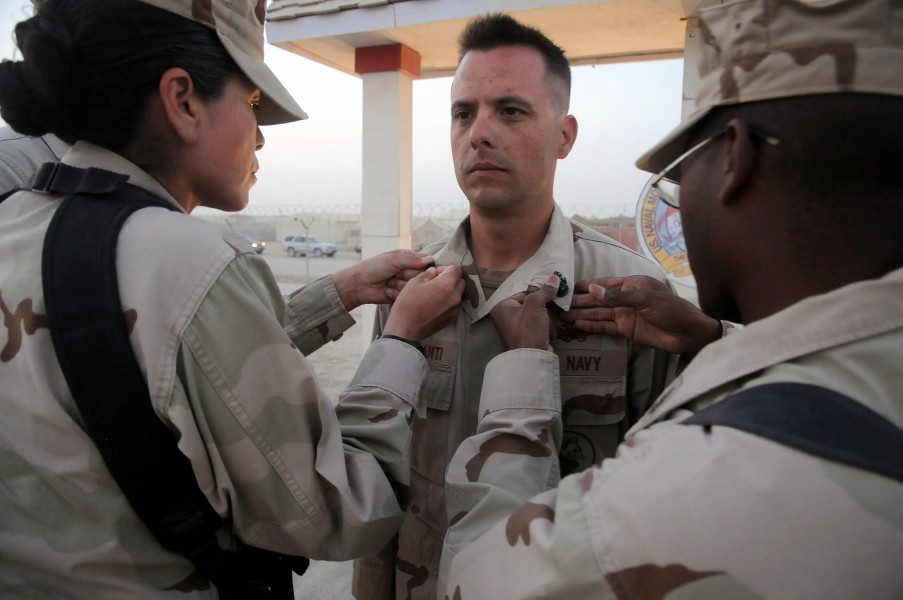 US Navy 100916-N-0475R-137 Chief Equipment Operator Thomas Colesanti, center, assigned to the Naval Mobile Construction Battalion (NMCB) 5, has his