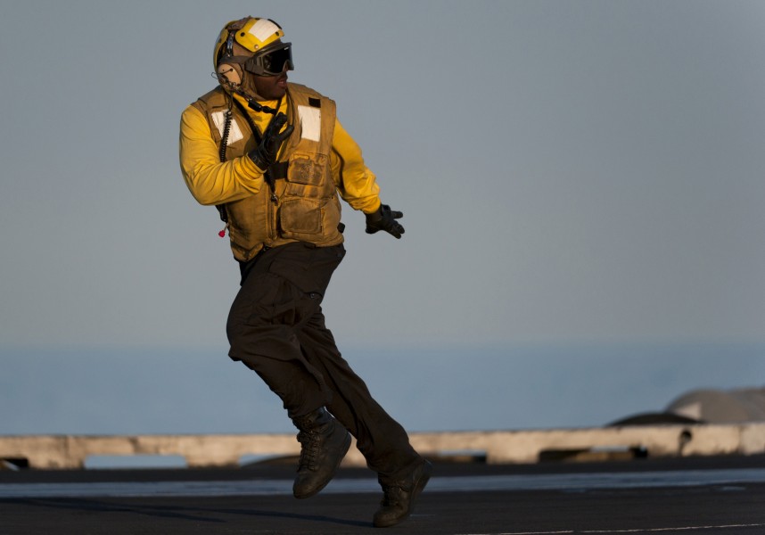 US Navy 110208-N-7981E-016 Aviation Boatswain's Mate (Handling) Airman Dominique McGhee runs to position himself to guide an aircraft aboard the Ni