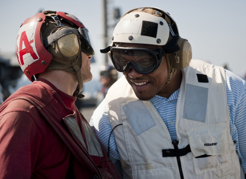 US Navy 110216-N-DR144-199 William Henderson, a fullback for the Green Bay Packers football team, speaks with an aviation ordnanceman on the flight