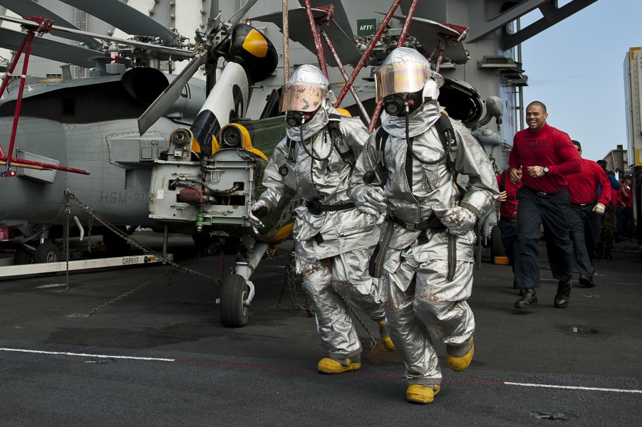 US Navy 110805-N-BT887-489 Aviation Boatswain's Mate Airman Patrick Sumbler, left, and Aviation Boatswain's Mate 3rd Class Jason Williams run acros