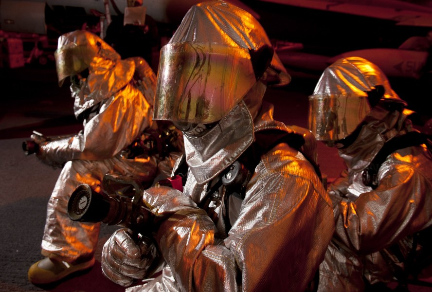 US Navy 110920-N-DR144-196 Air Department Sailors in hot suits fight a simulated fire in a hangar bay fuel station during a general quarters drill 
