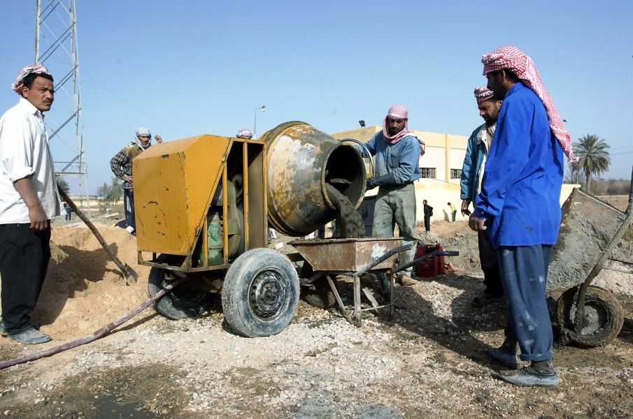 Workers with a cement mixer in Iraq