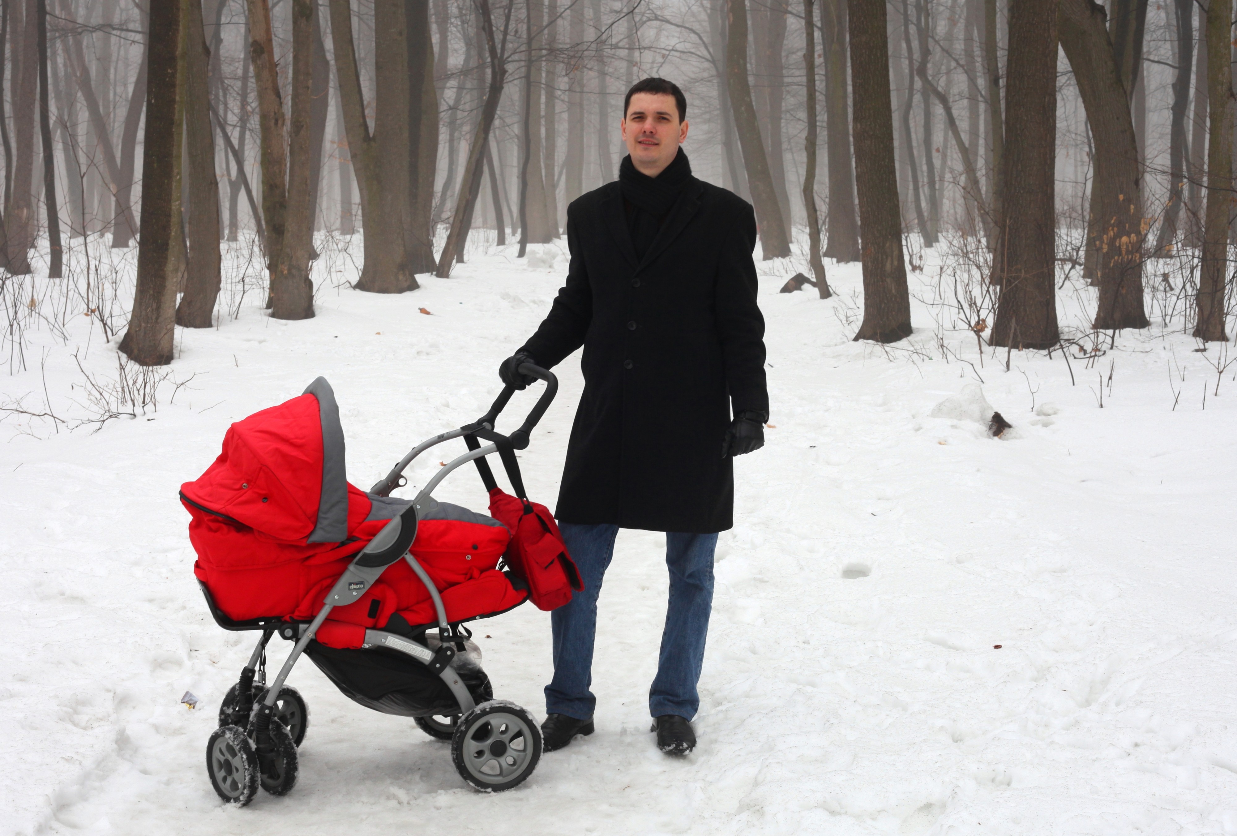 a handsome Catholic man with his baby daughter in a park