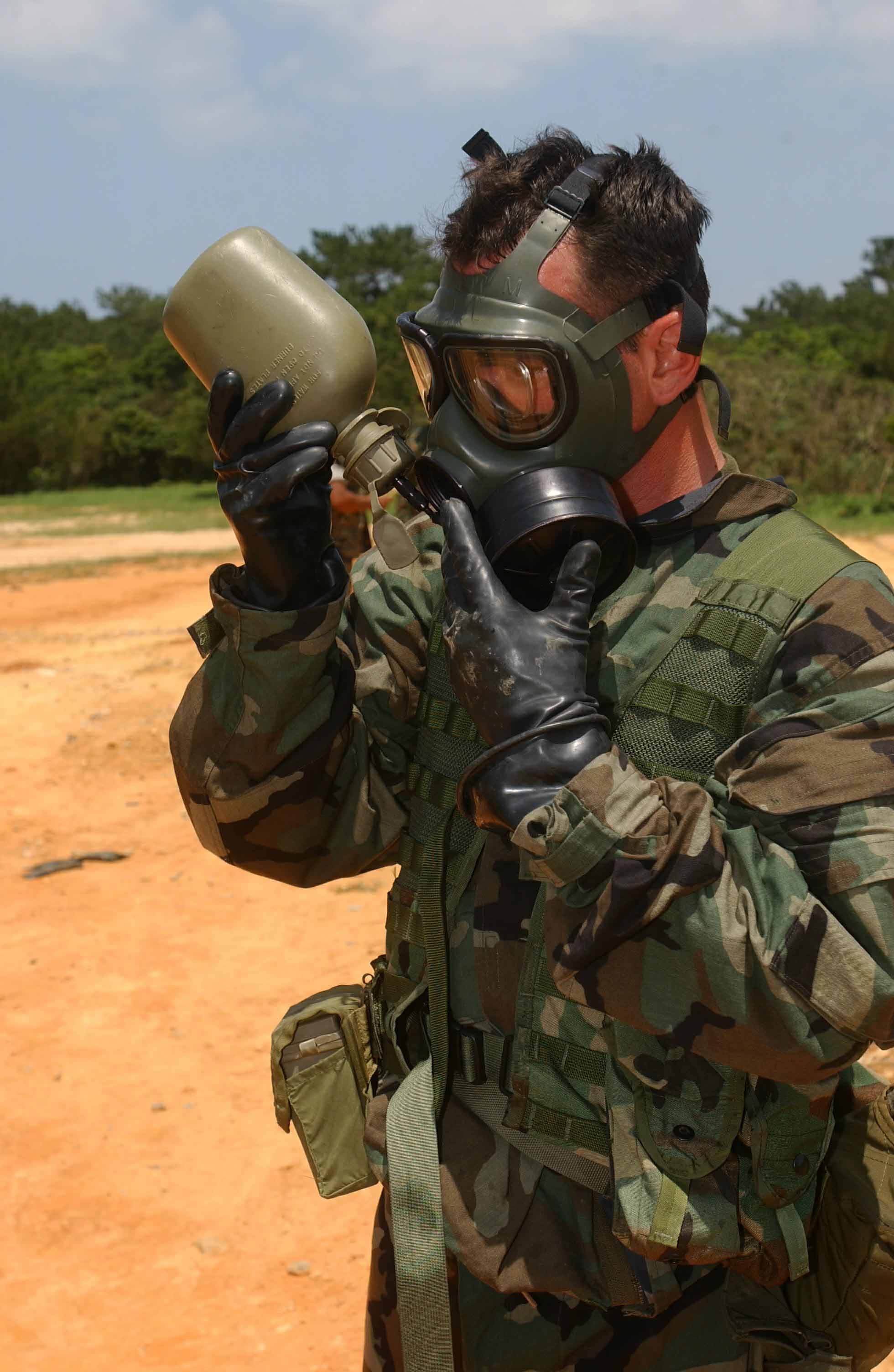 US Navy 030428-M-1852W-037 Hospital Corpsman John Copeck assigned to 3D Medical Battalion, Training Company, takes a break to hydrate after connecting his canteen to his gas mask