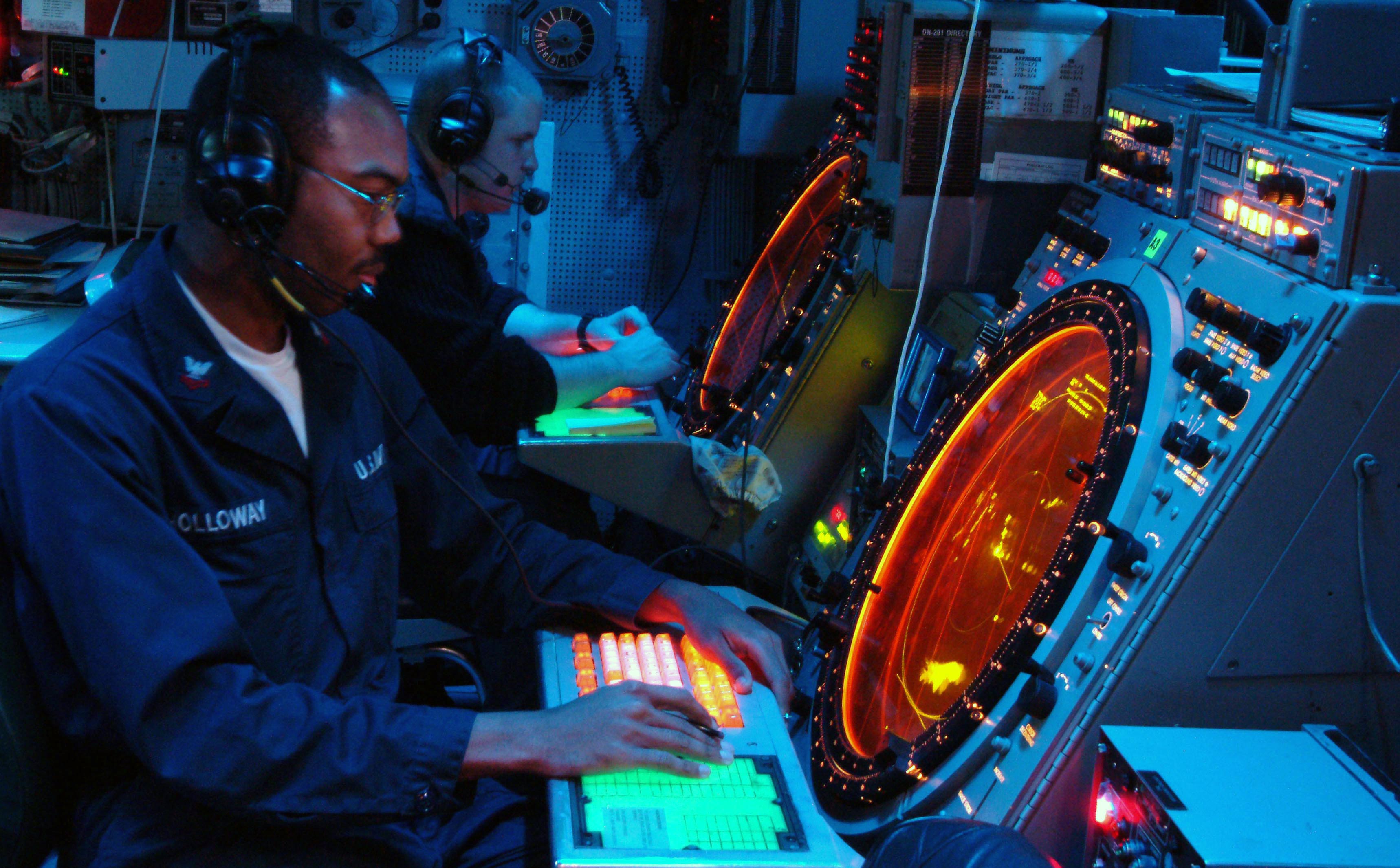 US Navy 030428-N-9802B-001 Air Traffic Controller 2nd Class Joey Holloway and Air Traffic Controller Airman Nicholas Colvin monitor the SPN-43 Precision Approach Radar from the Helicopter Direction Center (HDC) during flight op