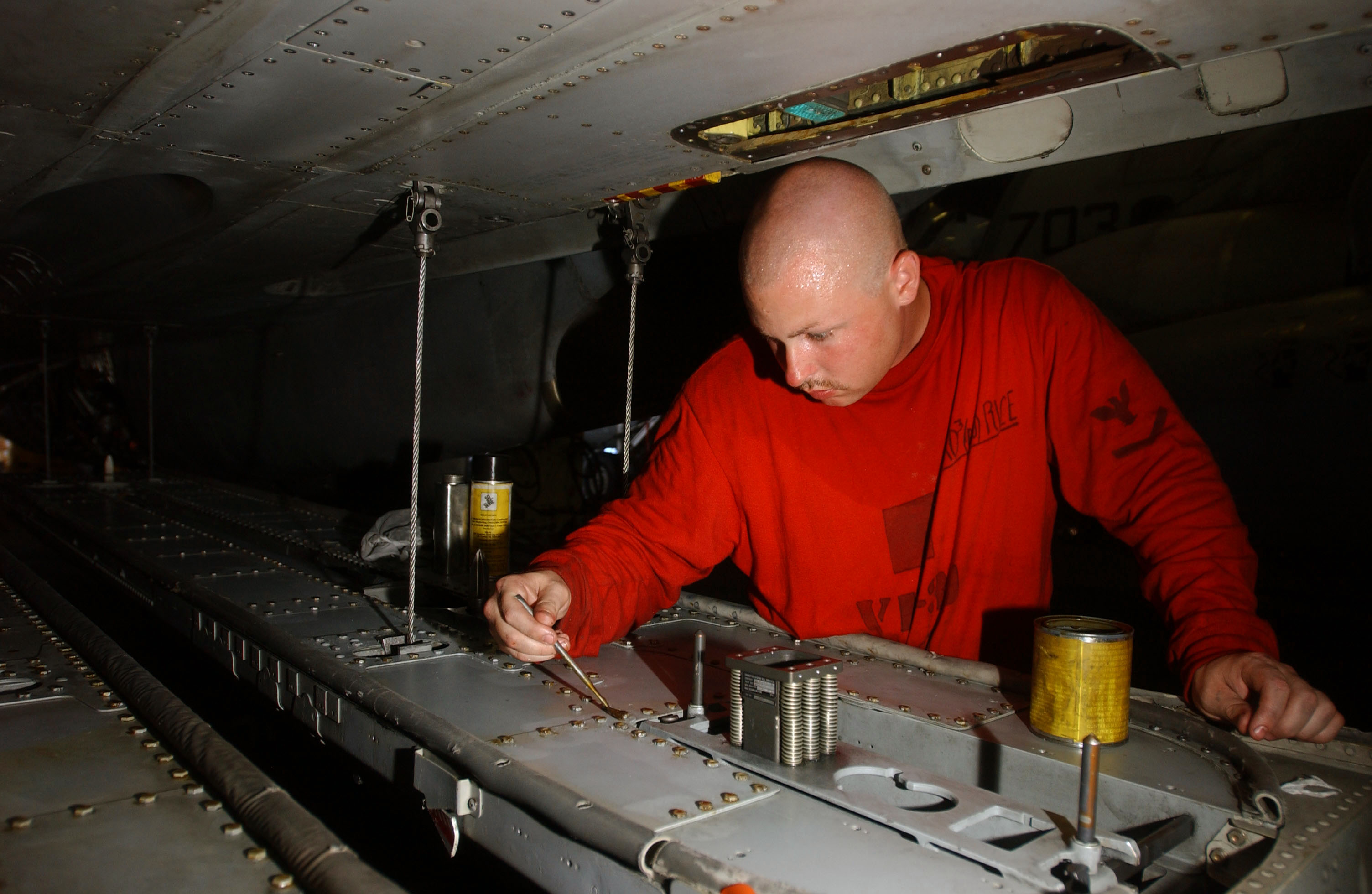 US Navy 040804-N-1573O-016 Aviation Ordnanceman 3rd Class Christopher Rice of Lexington, N.C., applies a corrosion prevention compound to the weapon rails of an F-14D Tomcat