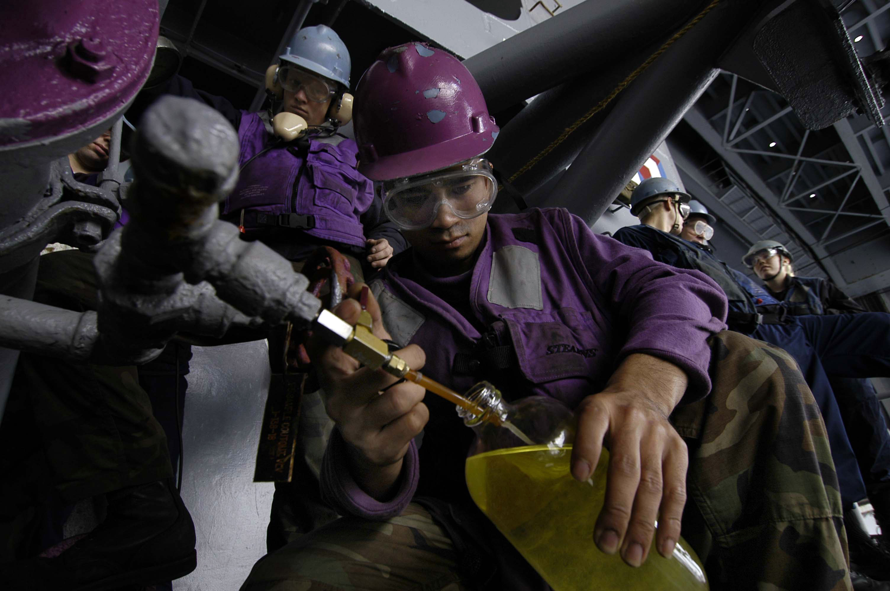 US Navy 051116-N-3946H-063 Aviation Boatswain's Mate 3rd Class Michael Patacsil of Oxnard, Calif., collects fuel samples during a replenishment at sea