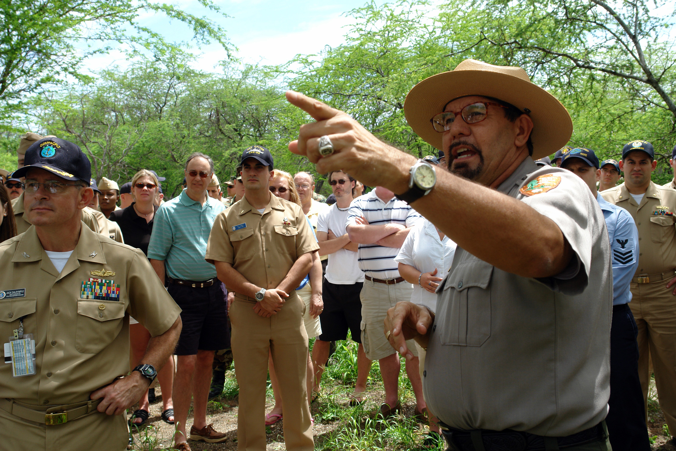 US Navy 060316-N-9643K-001 National Park Service Ranger Daniel Martinez addresses a group of Sailors from the Pearl Harbor Surface Navy Association (SNA) at the site of the USS Arizona relics