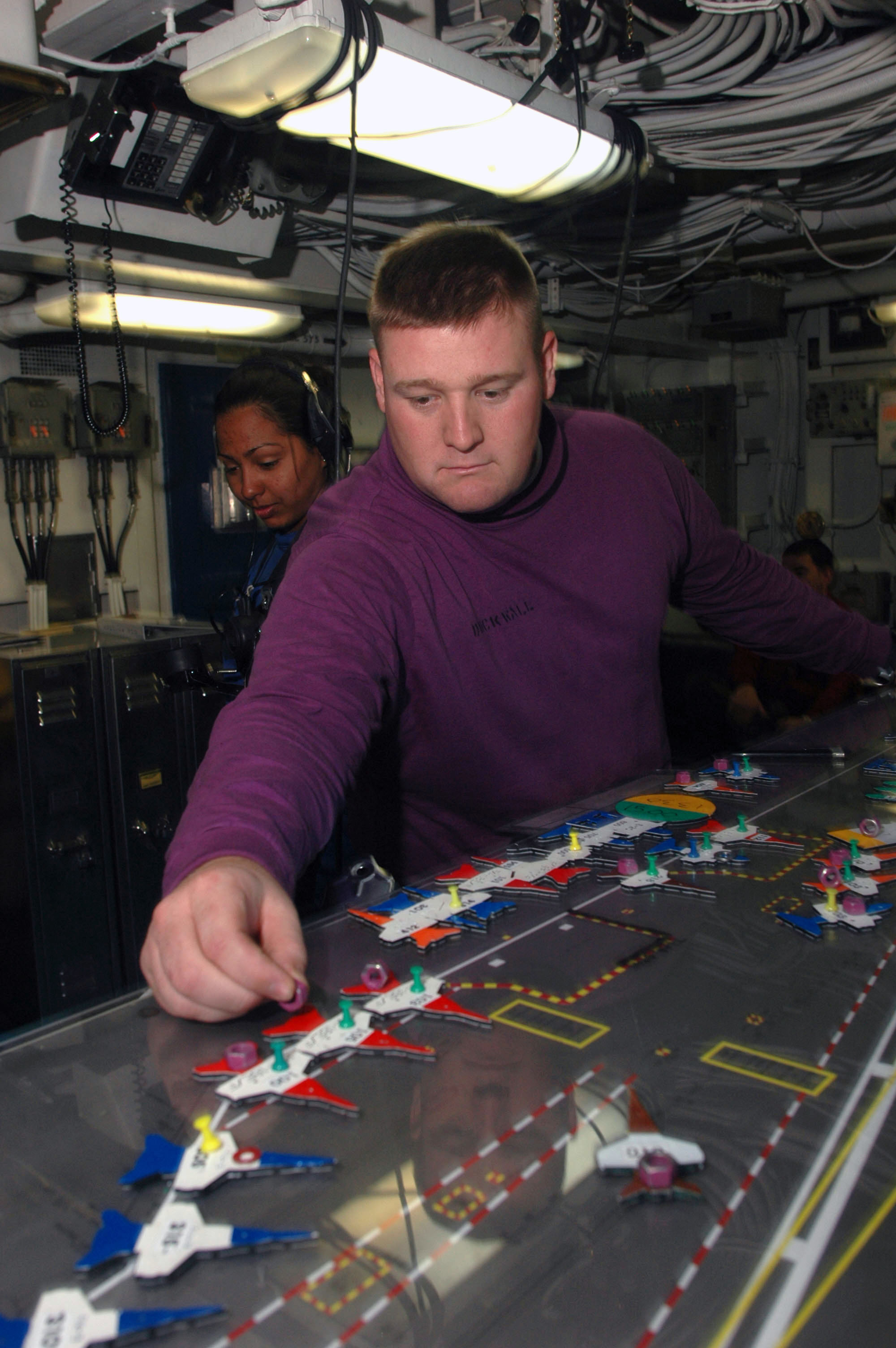 US Navy 060628-N-2659P-013 Aviation Boatswain's Mate Fuel 2nd Class Michael Duckwall uses a table diagram to organize the movement and placement of aircraft on the flight deck aboard the Nimitz-class aircraft carrier USS John C