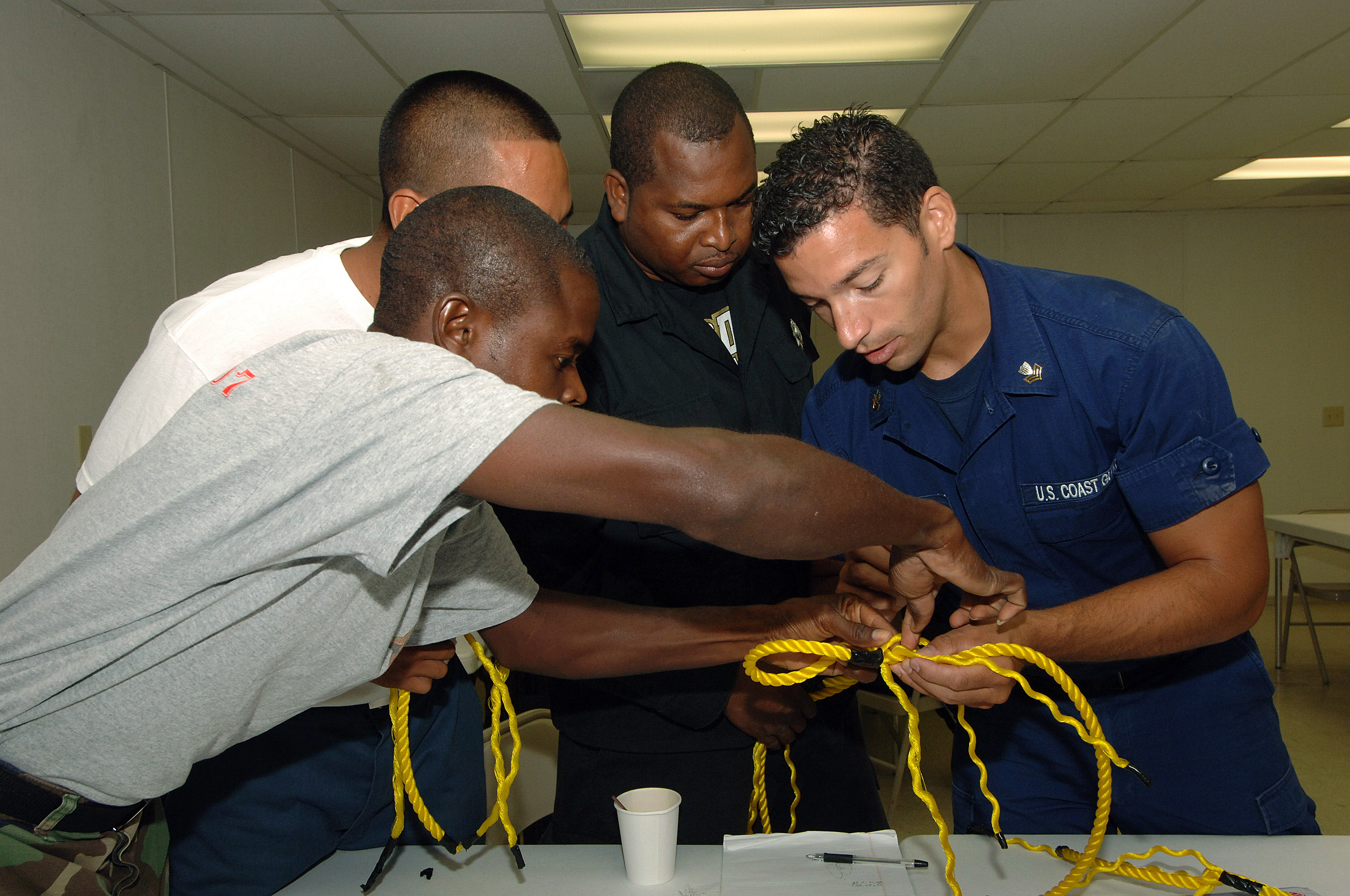 US Navy 070621-N-0989H-052 BM1 Ernest Ramos assists members of the Belize National Coast Guard, Belize Police Force, and the Belize Defense Force with line splicing during coxswain training aboard High Speed Vessel (HSV) 2 Swif