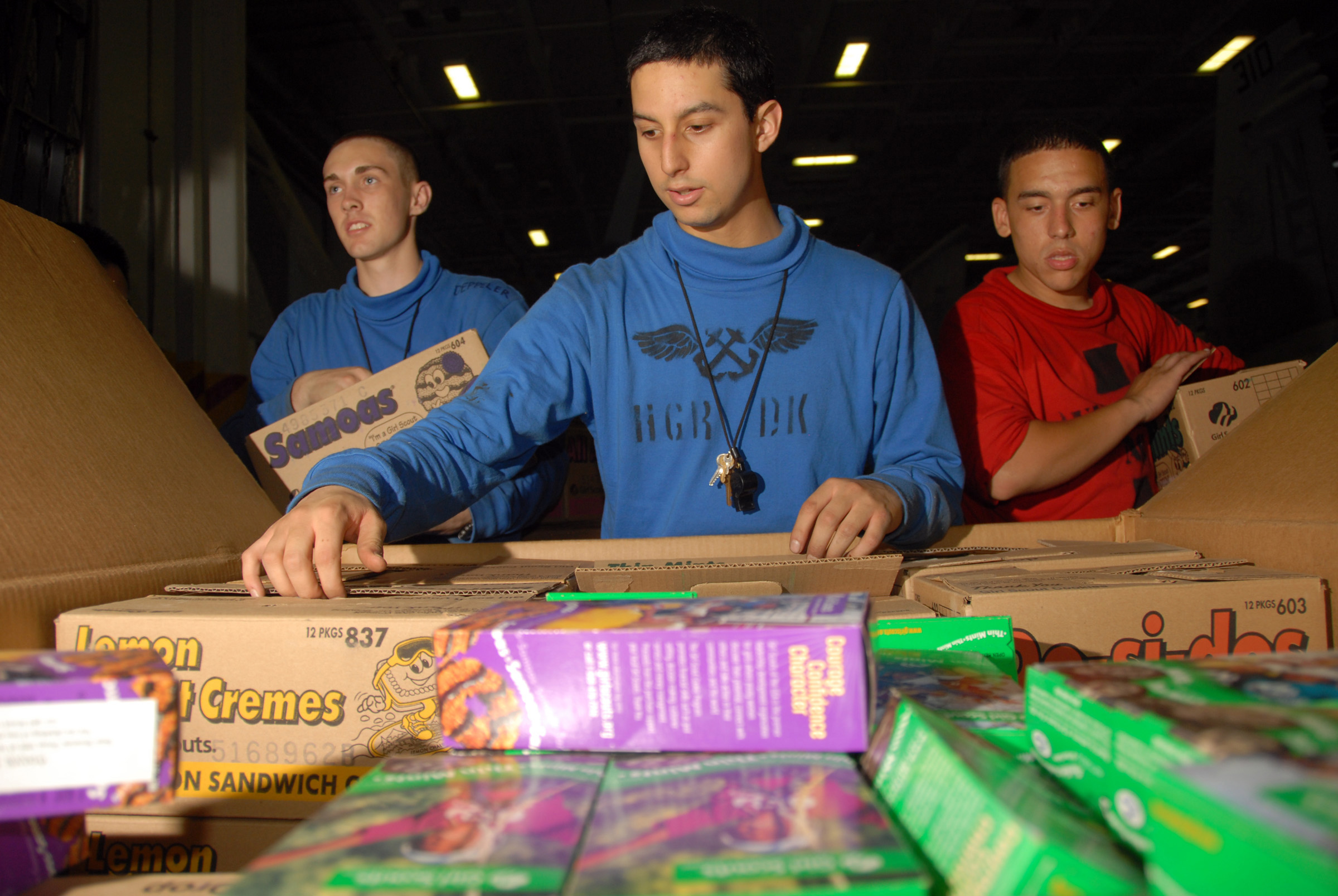 US Navy 080709-N-9450M-066 Aviation Boatswain's Mate (Handling) Airman Cristian Orkiz distributes free Girl Scout Cookies sent by Junior Troop 818 of Woodinville, Wash