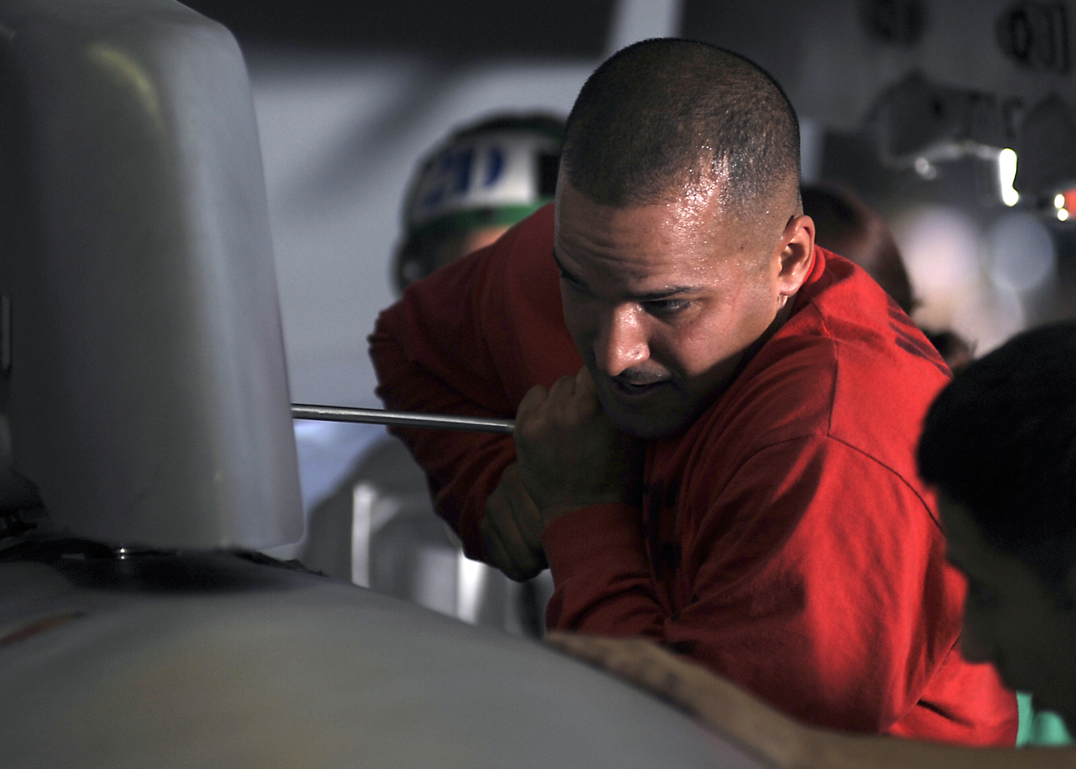 US Navy 080722-N-7241L-001 Aviation Ordnanceman 1st Class Hiran Carrero loosens a nut holding one of the fuel tanks of an F-A-18F Super Hornet