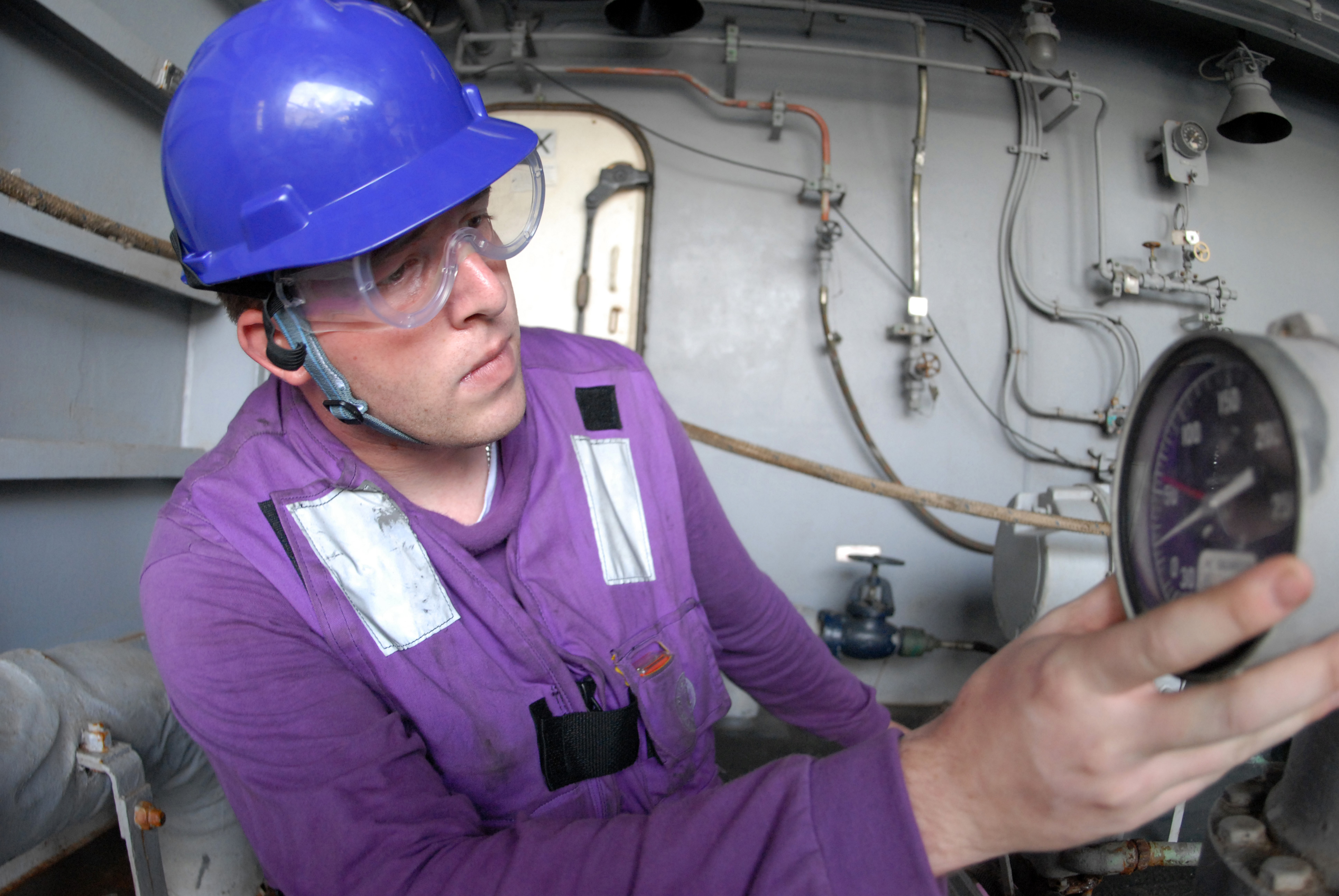 US Navy 081015-N-3610L-104 Aviations Boatswain's Mate (Fuel) 2nd Class Cody Baker, from Phoenix, checks the pressure on a valve in fuel replenishment station 9 aboard the Nimitz-class aircraft carrier USS Ronald Reagan (CVN 76)