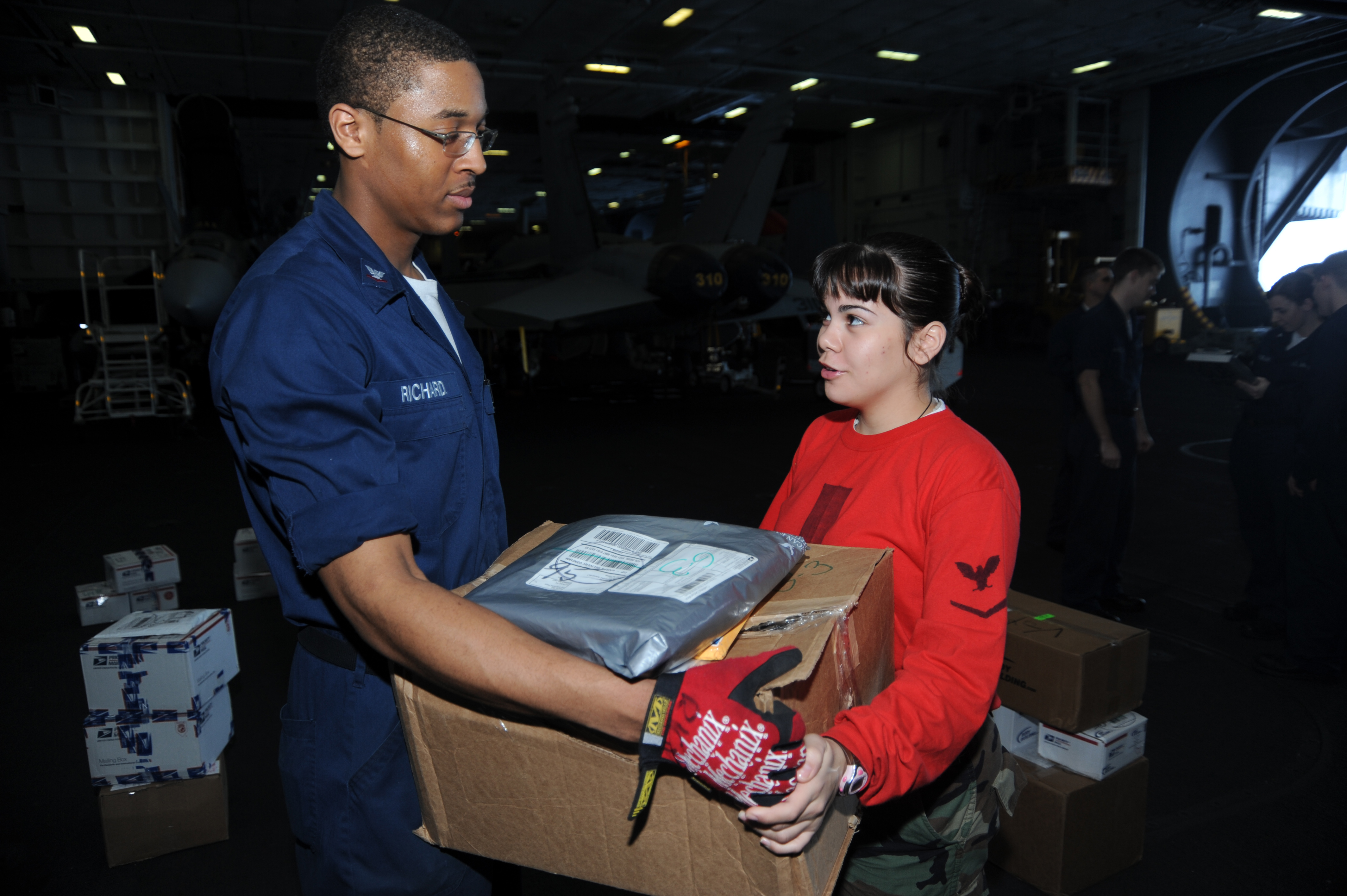 US Navy 090104-N-2908M-004 Postal Clerk 3rd Class Justin Richard gives mail to Aviation Ordnanceman 3rd Class Ivianna Ortiz during mail call