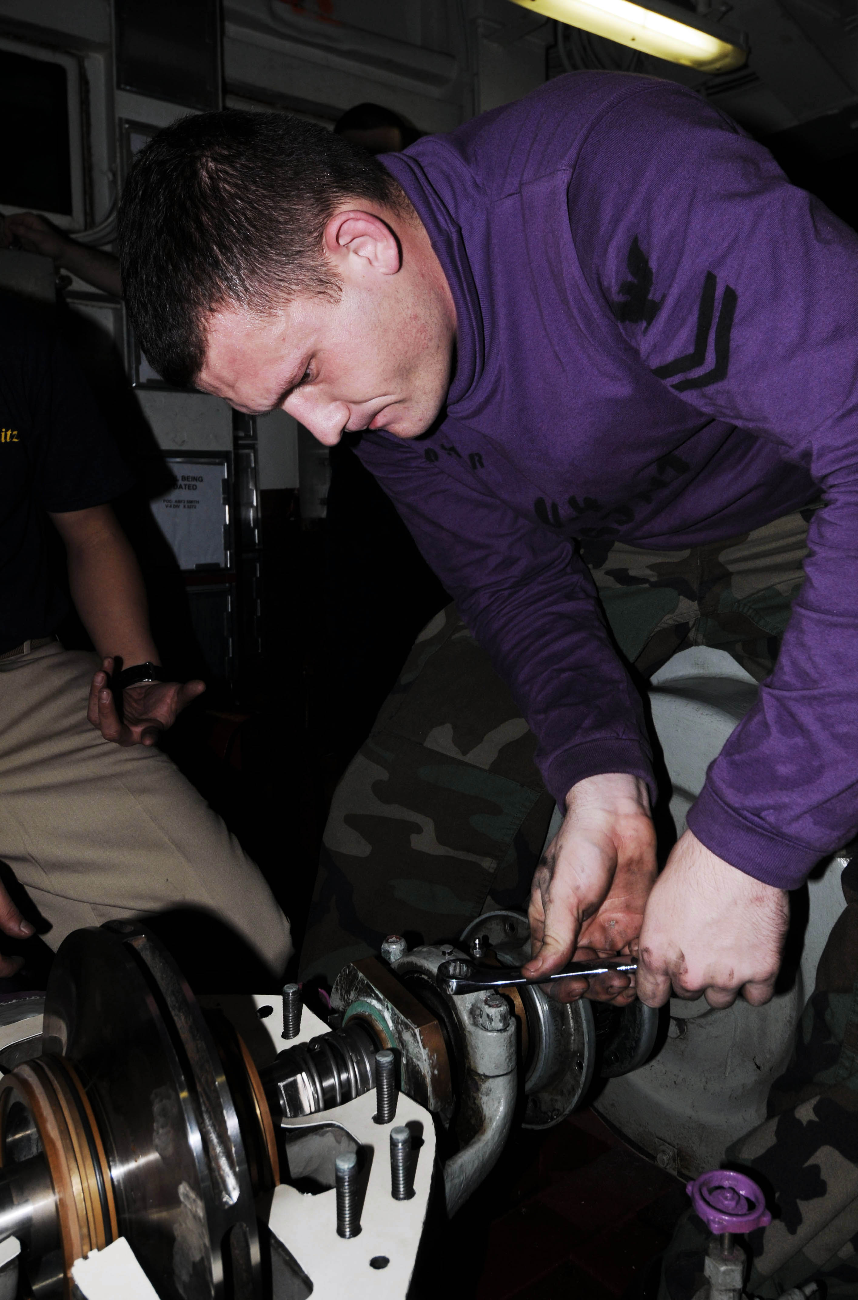 US Navy 091014-N-3038W-203 Aviation Boatswain's Mate (Fuels) 2nd Class Michael Foster performs maintenance on a fuel pump in the number ^2 pump room aboard the aircraft carrier USS Nimitz (CVN 68)