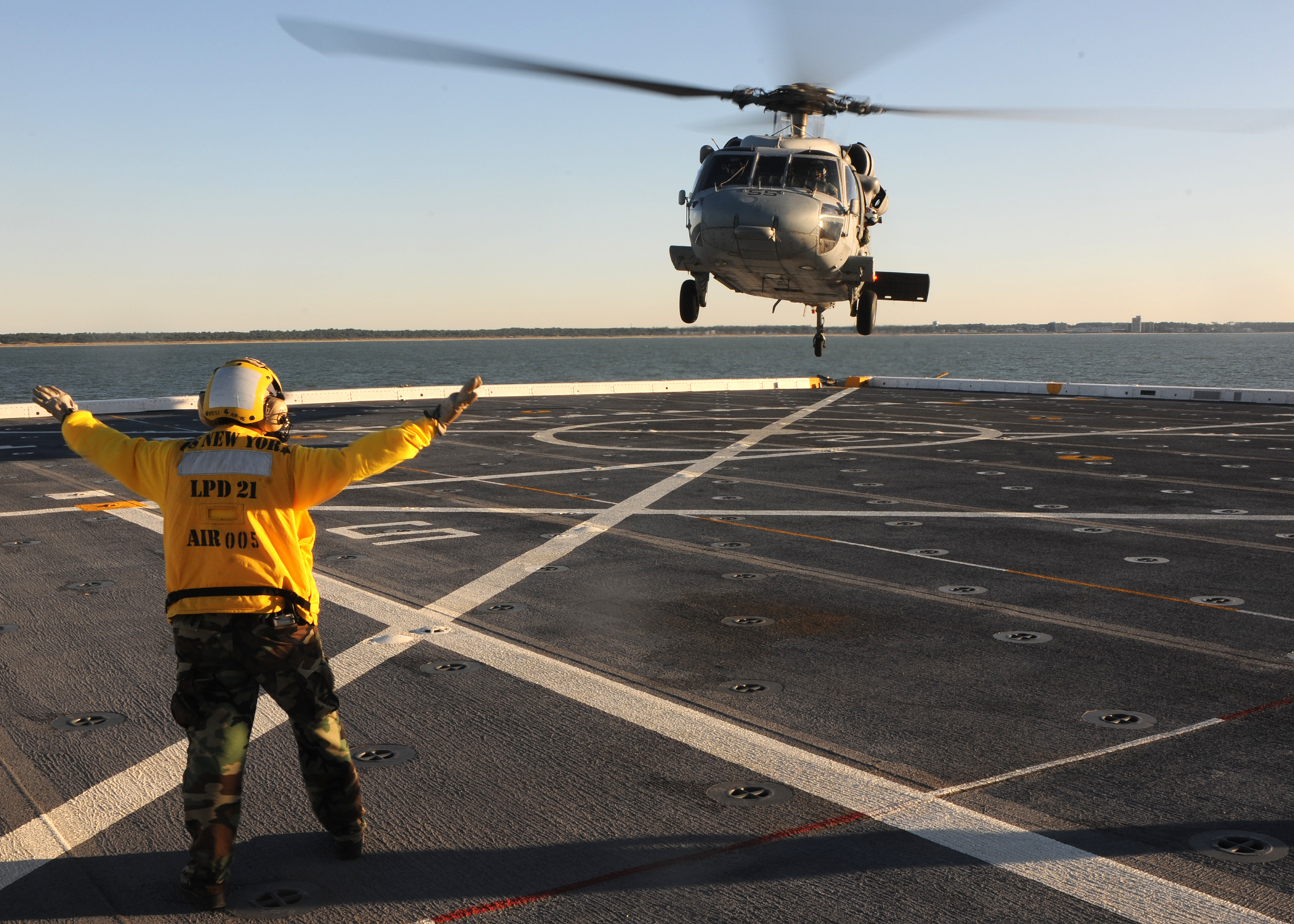 US Navy 091019-N-2147L-004 Aviation Boatswain's Mate (Handler) Airman Hannah Marihugh directs an SH-60 Sea Hawk helicopter to land